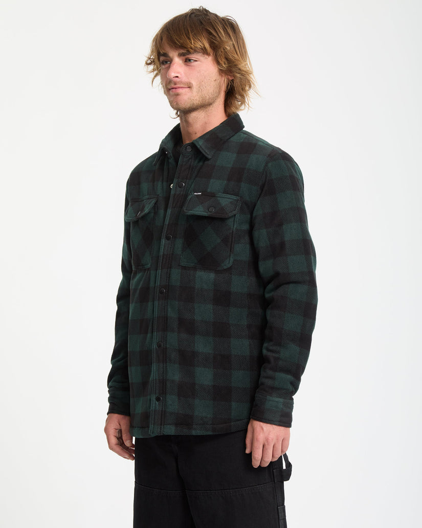 Man wearing a green and black plaid shirt on a white background
