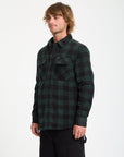 Man wearing a green and black plaid shirt on a white background
