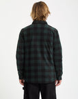 Person wearing a green and black plaid shirt on a white background