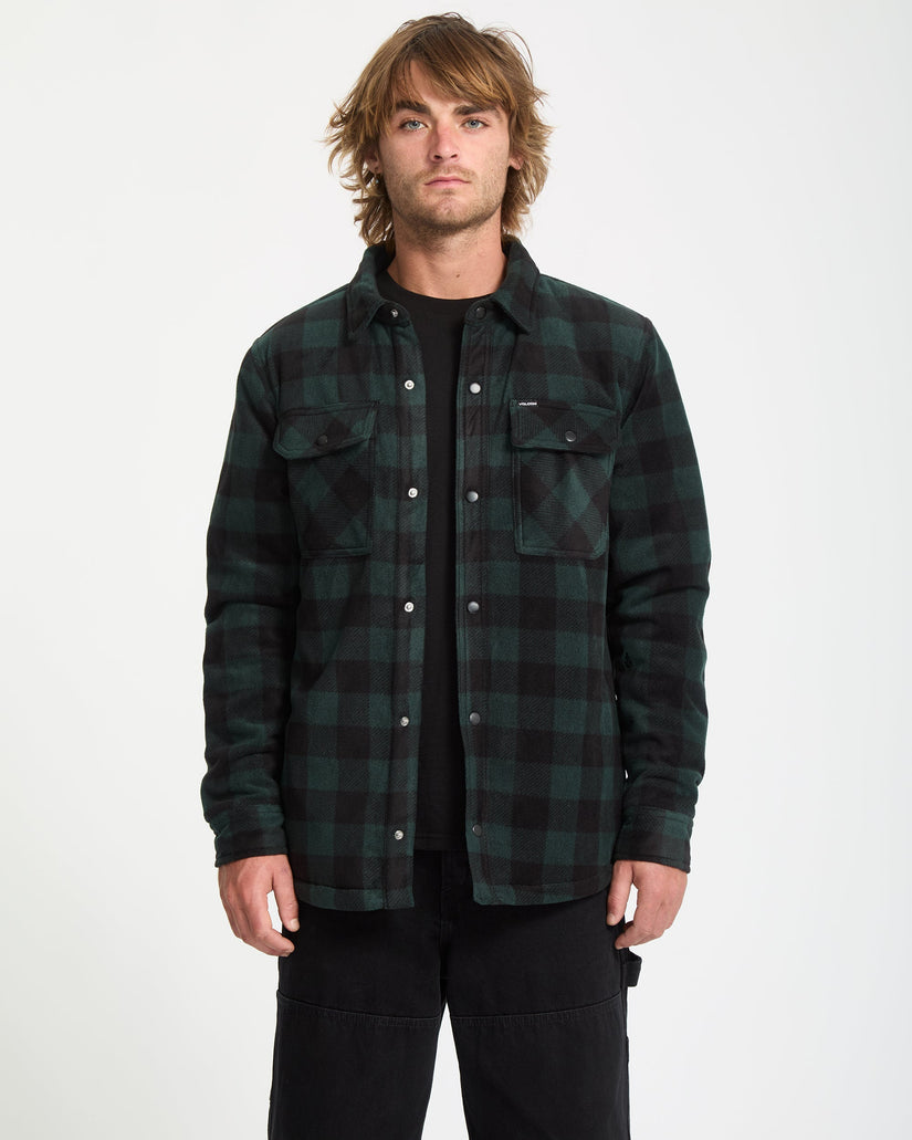 Man wearing a green and black plaid shirt on a white background