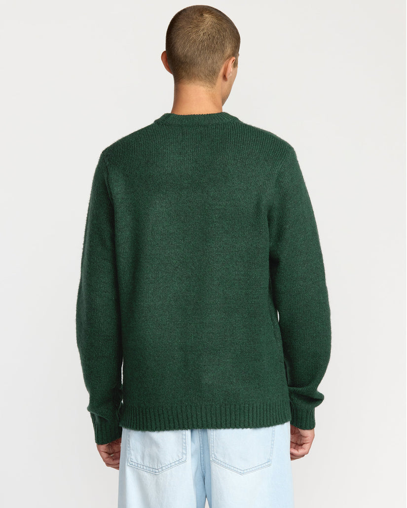 Person wearing a green sweater on a light gray background