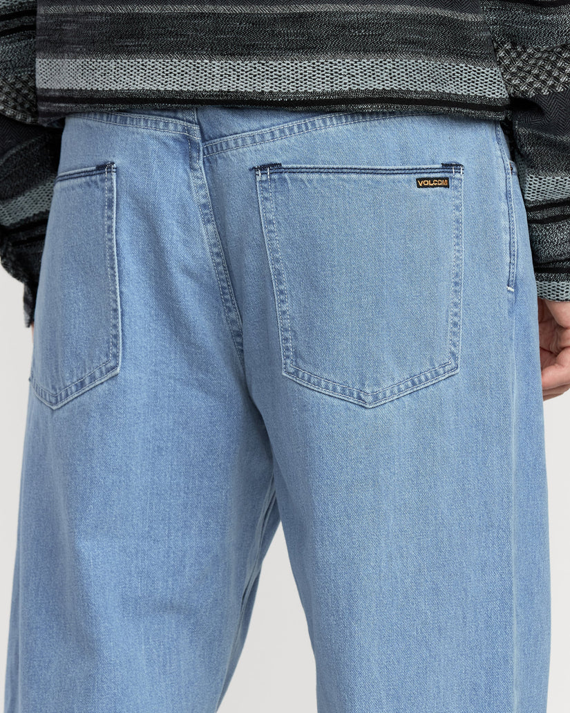 Light blue jeans with a brand logo on the pocket against a neutral background