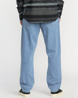 Person wearing blue jeans and a patterned sweater on a white background