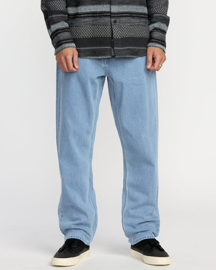 Person wearing light blue jeans and a patterned sweater on a white background