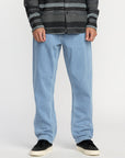 Person wearing light blue jeans and a patterned sweater on a white background