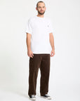 Man wearing a white t-shirt and brown pants on a white background