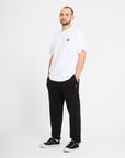 Man wearing a white t-shirt and black pants on a white background