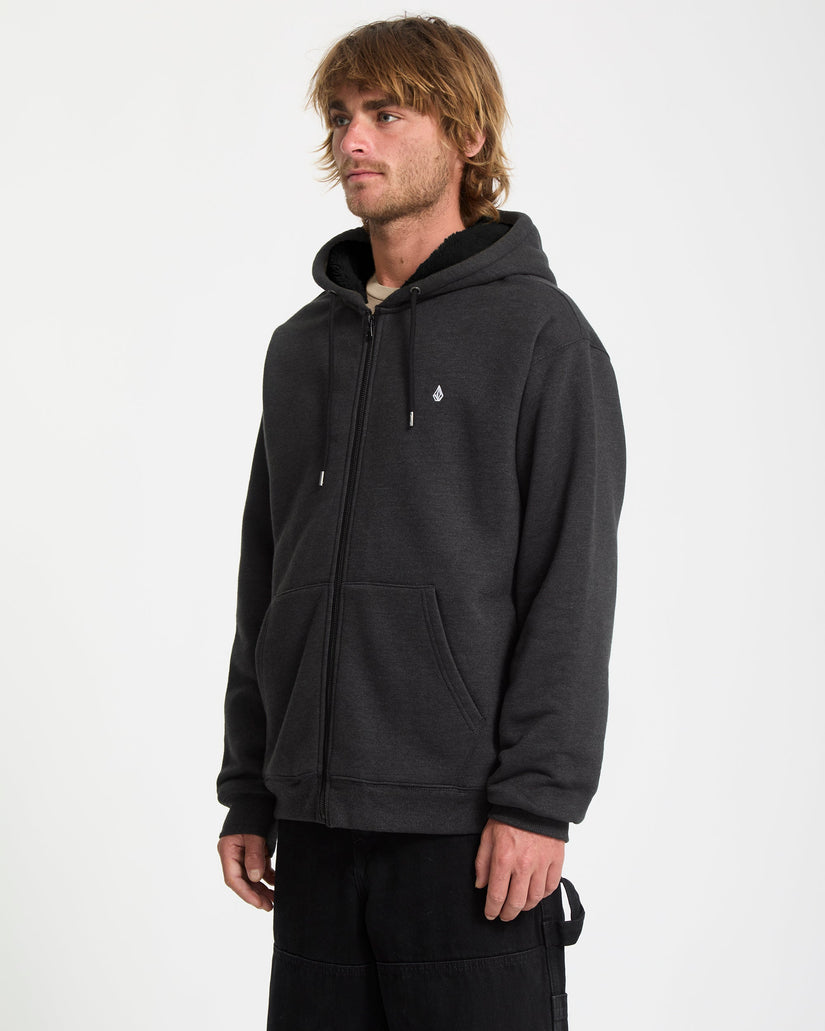 Man wearing a black hoodie with a small logo on a white background