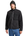 Man wearing a black fleece jacket and beanie on a white background