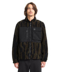 Man wearing a black and brown patterned jacket on a white background