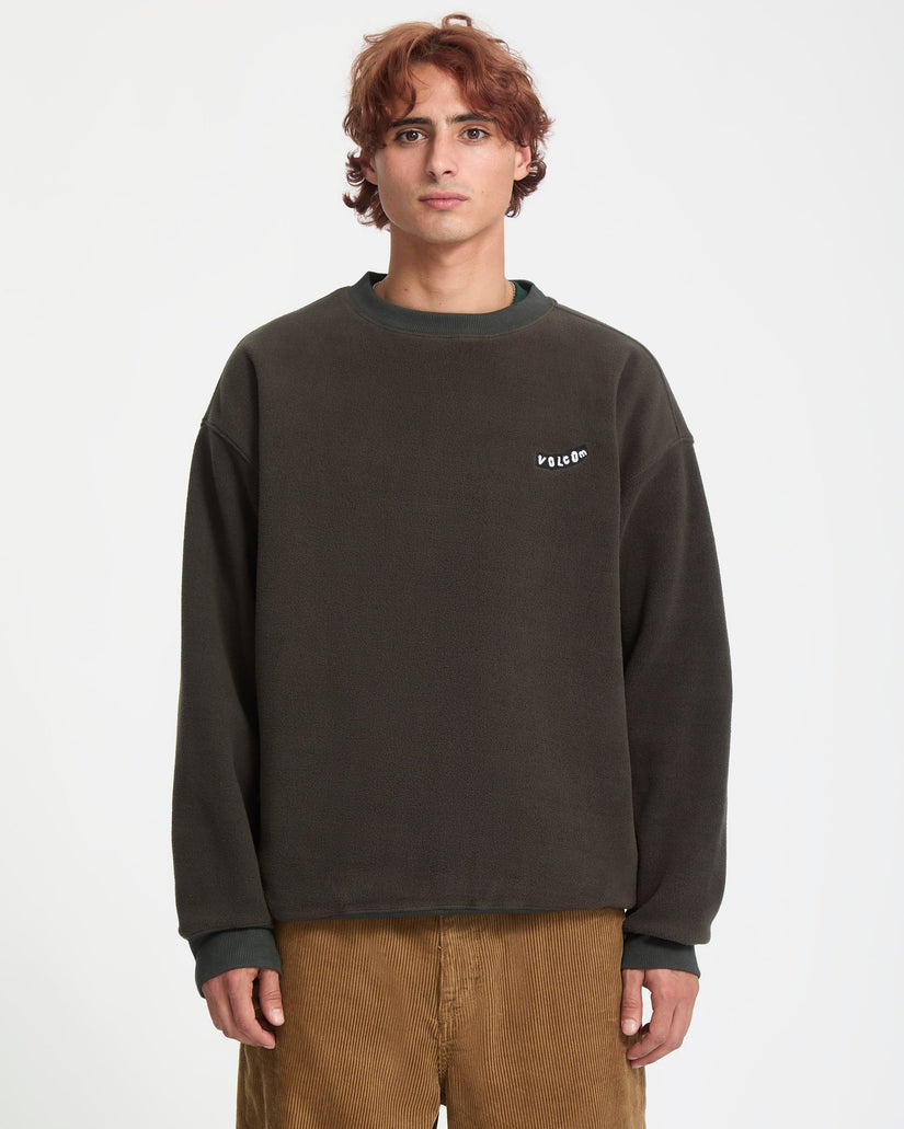Person wearing a dark gray sweatshirt with a logo on a light gray background