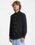 Man wearing a black button-up shirt on a white background