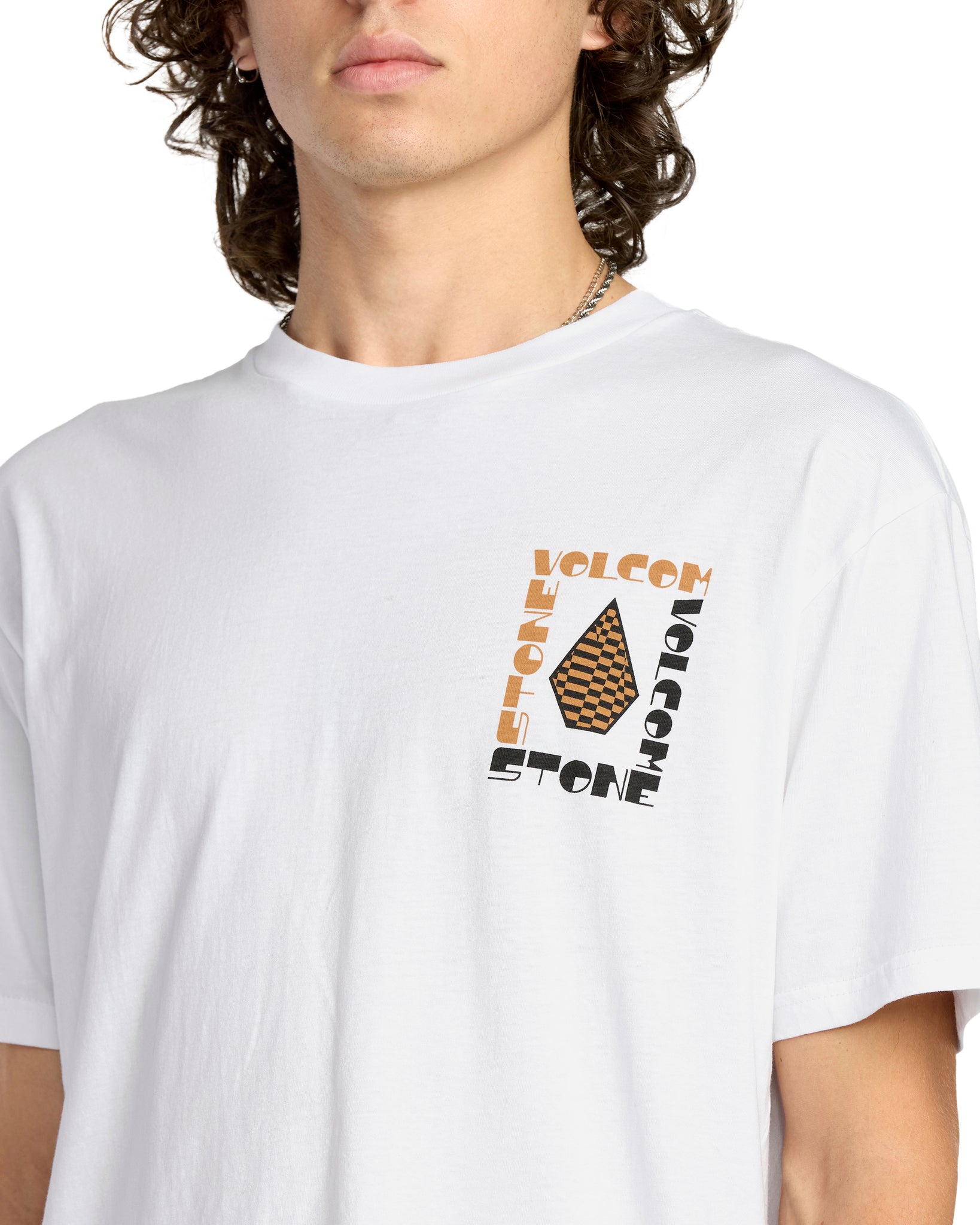 Person wearing a white t-shirt with Volcom graphic design