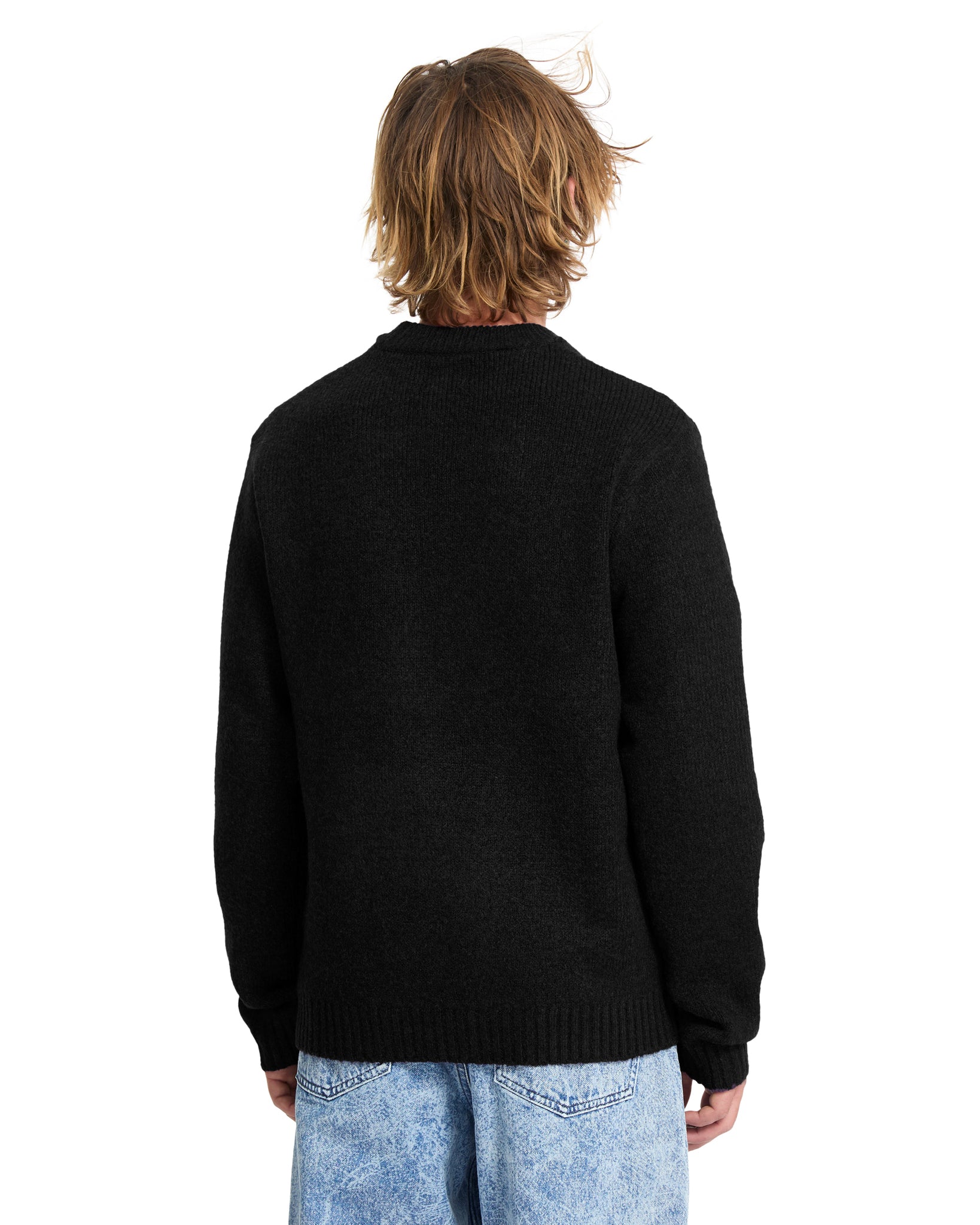Person wearing a black Volcom sweater from behind on a white background bought at Mango Surfing