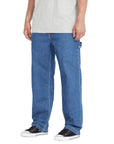 Person wearing blue jeans and black sneakers on a white background