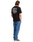 Person wearing a black t-shirt with colorful graphics and text, standing against a white background